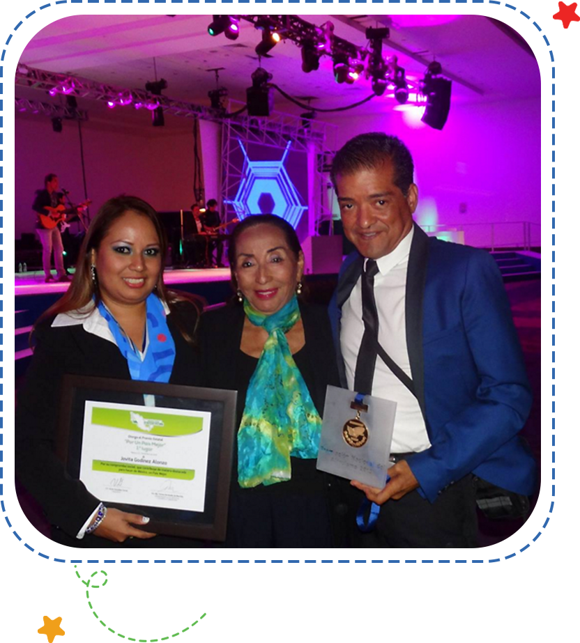 A group of people holding certificates in front of a stage.