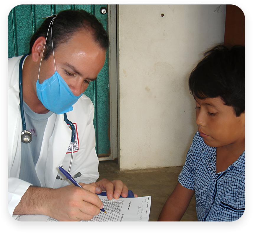 A doctor is writing on paper with a boy.