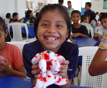 A girl holding a stuffed animal in her hands.