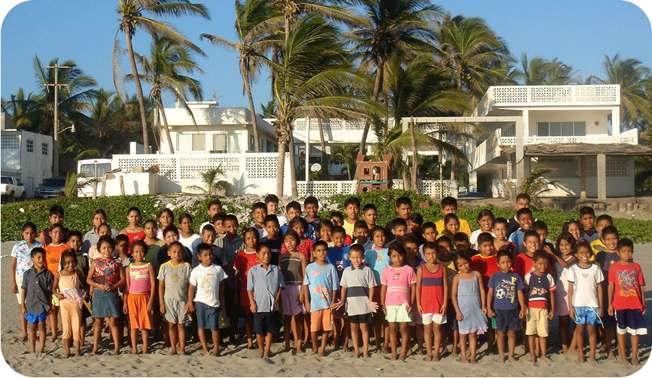 A group of people standing on top of a sandy beach.